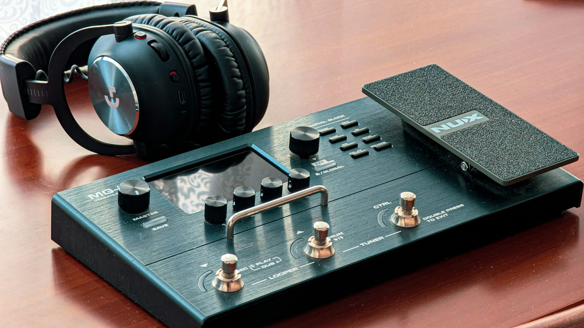 Headphones rest on a guitar effects pedal