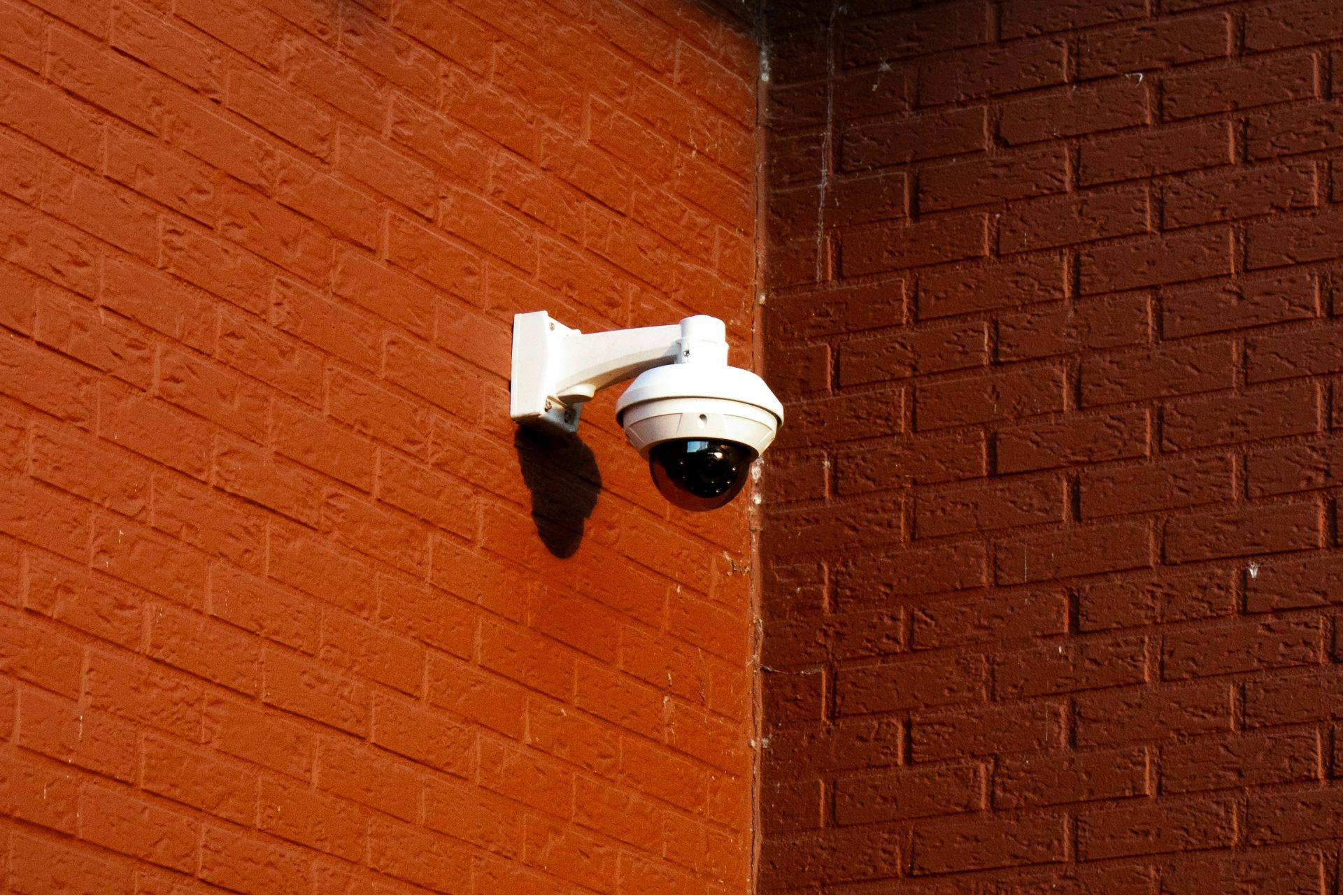 Security camera mounted on a brick wall.
