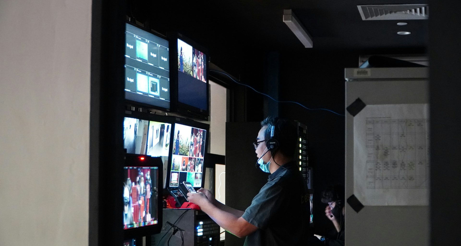 man in gray t-shirt standing near black flat screen tv